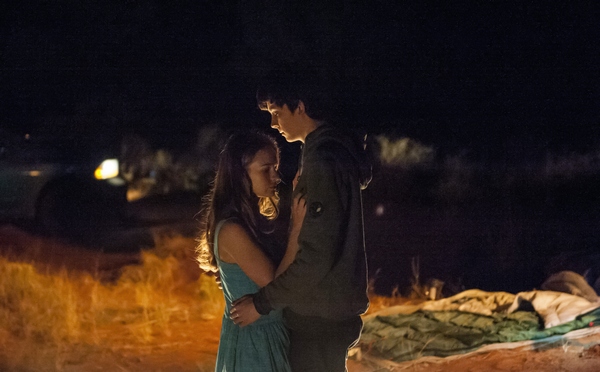 Tulsa (Britt Robertson) and Gardner (Asa Butterfield) embrace by a campfire under the stars at the Grand Canyon