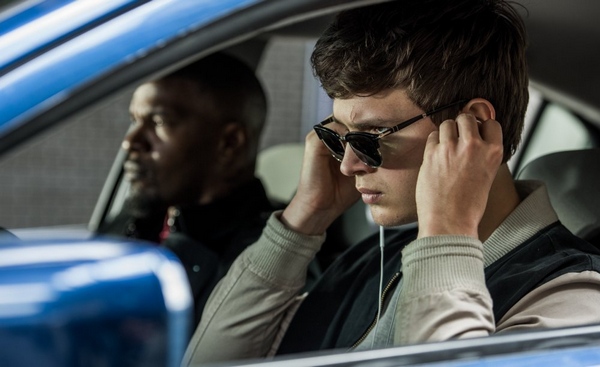 Baby (ANSEL ELGORT) and Bats (JAMIE FOXX) on the way to the post office job with Buddy (JON HAMM) and Darling (EIZA GONZALEZ) as cops pull up next to them in TriStar Pictures' BABY DRIVER.